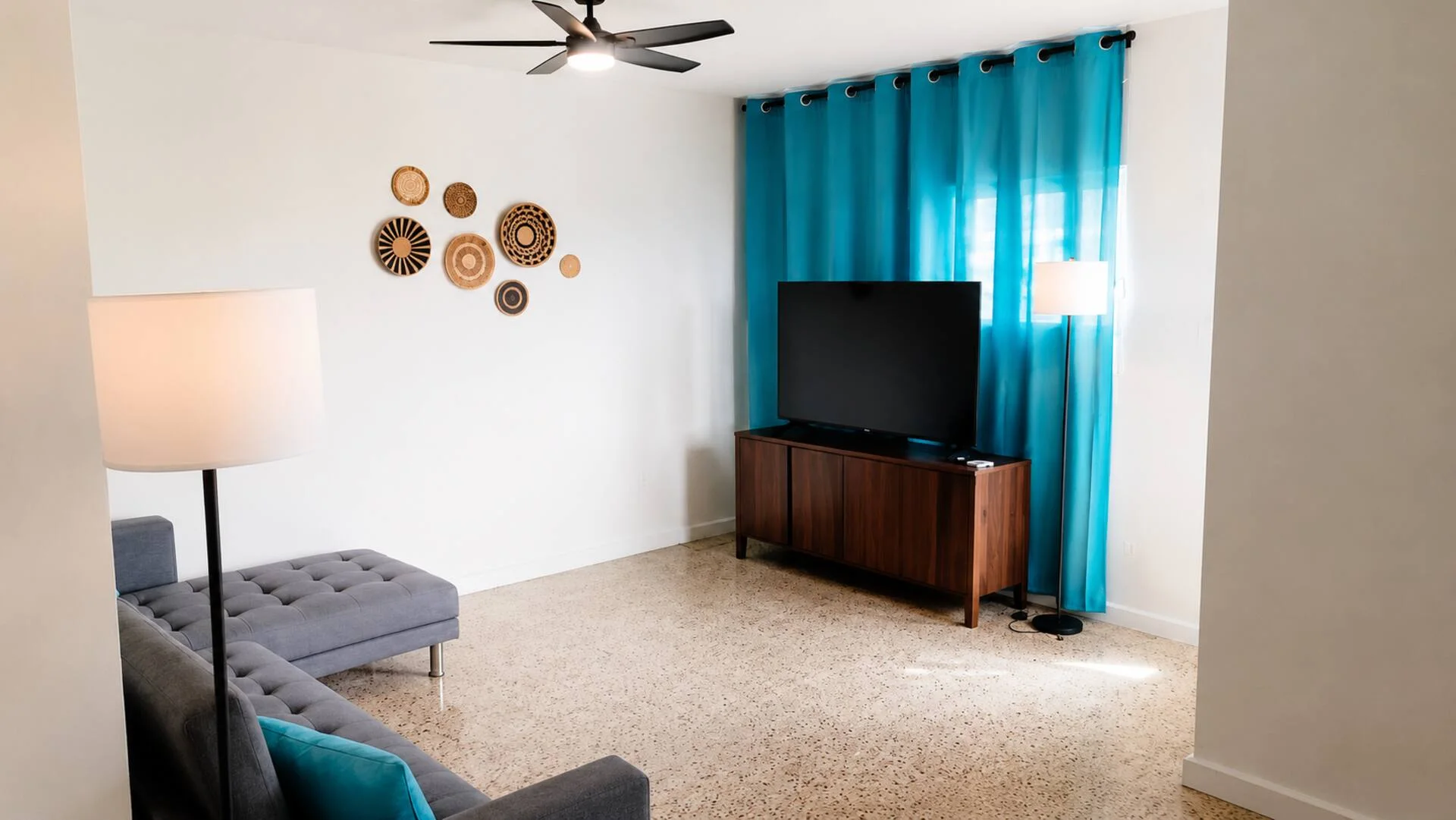 Salón con televisión y cortinas turquesa